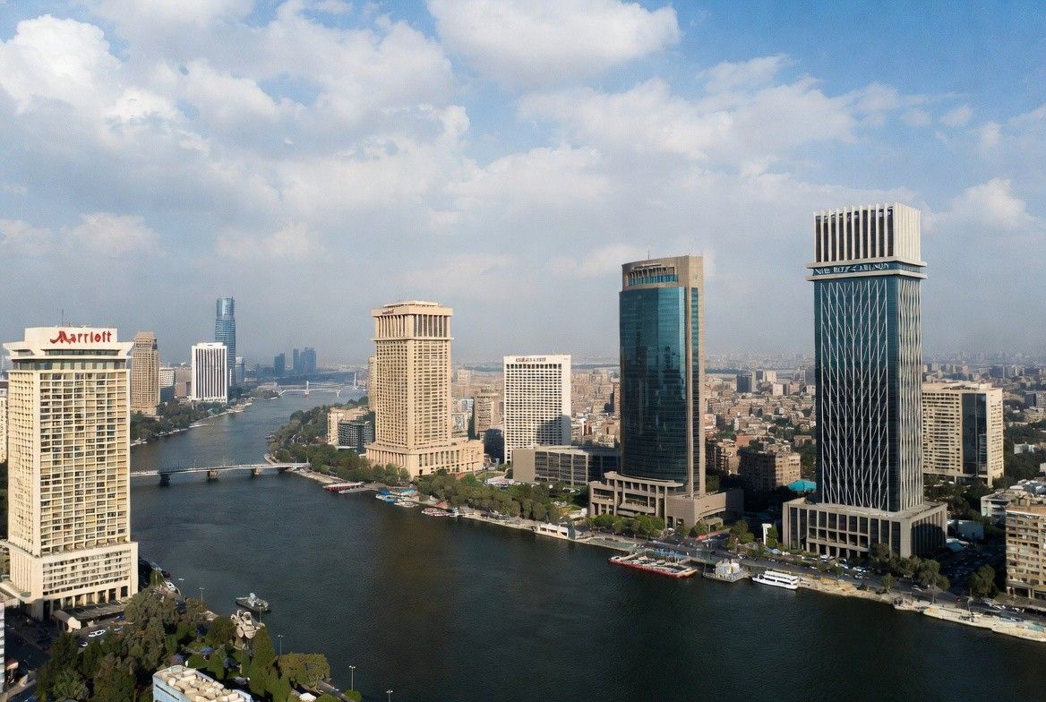 A shot of a Moroccan coastal resort with a prominent hotel, sandy beach, and clear sky
